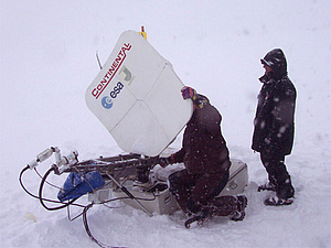 Two persons with a portable satellite ground station