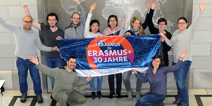 © TU Graz – BIB Staff and international students of TU Graz hold a colourful banner with the inscription “From Erasmus to Erasmus+ – a story of 30 years.”