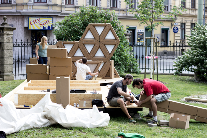 Die Architekturstudierenden Patrick Ernst und Robert Sterzing (v.l.) bauen eine Notunterkunft aus Wellkarton auf.