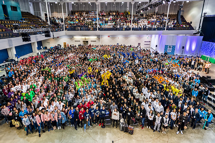 Gruppenfoto der rund 3000 teils in bunte Teamdresses Teilnehmerinnen und Teilnehmer von iGEM.