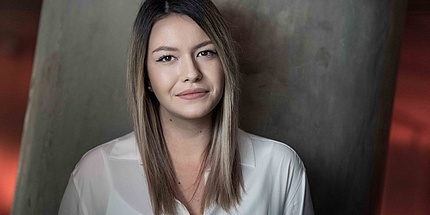 Portrait photo of a young woman in white blouse.