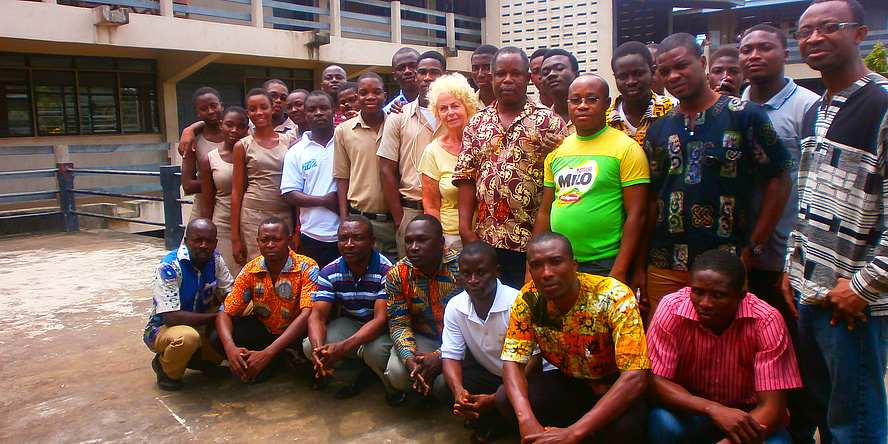 Margarete Grimus, surrounded by African workshop participants and experts, all in four rows ready to be photographed.