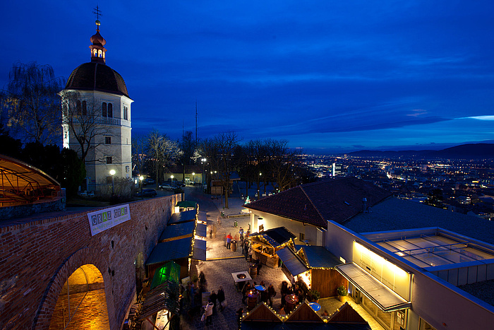 Christmas market at night from above, high above an illuminated city)
