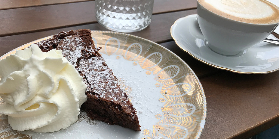 Coffee served with homemade cake and a glass of water.