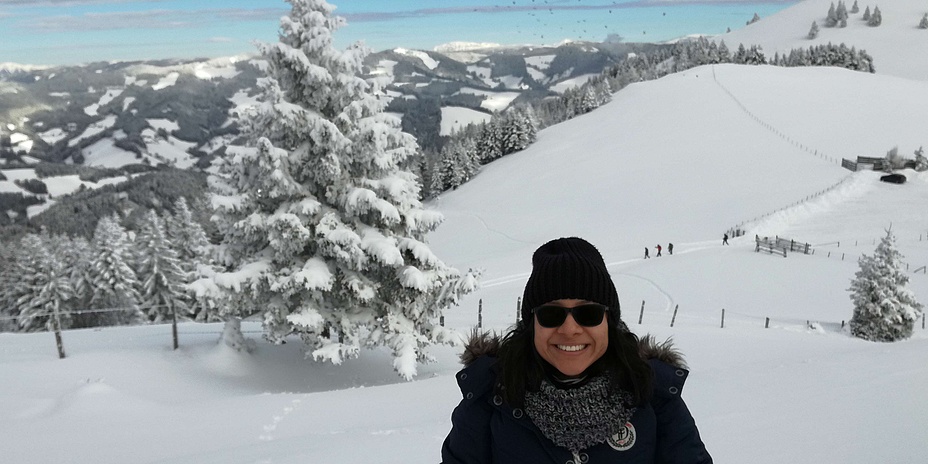 Junge Frau in Winterkleidung in verschneiter Berglandschaft