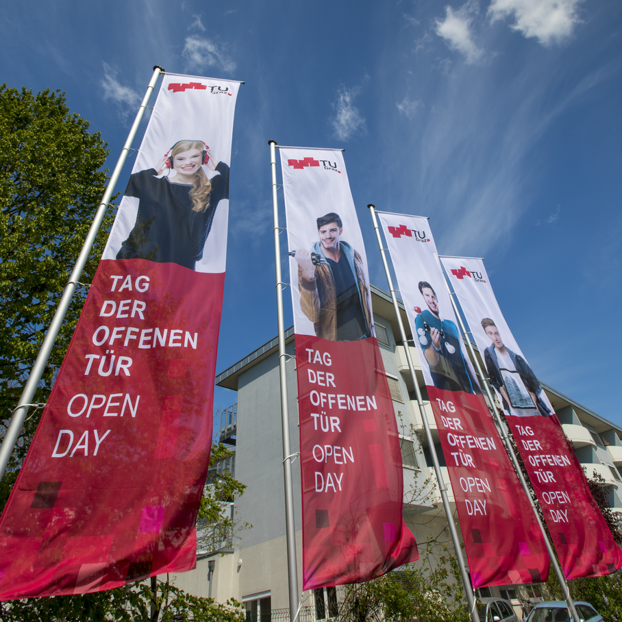 Fahnen mit Fotos von Studierenden und dem Text Tag der offenen Tür, Open Day.