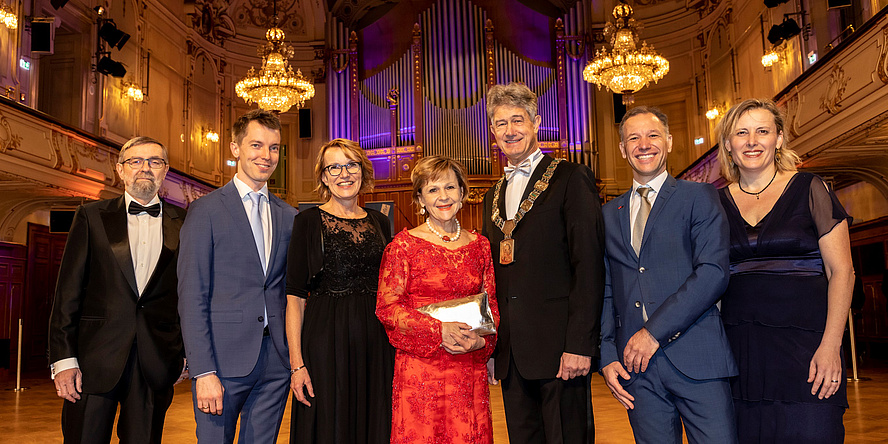 Gruppenbild mit drei Frauen und vier Männern in festlicher Garderobe