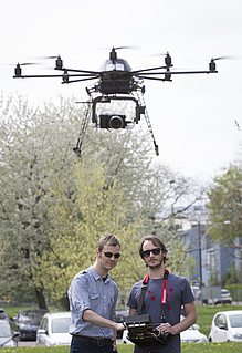 Two men with a flying drone.