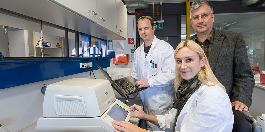 Two men and a woman with laboratory equipment