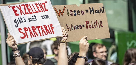 Protest signs: Excellence doesn’t come on a budget