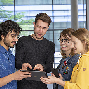 4 junge Leute schauen auf ein Tablet