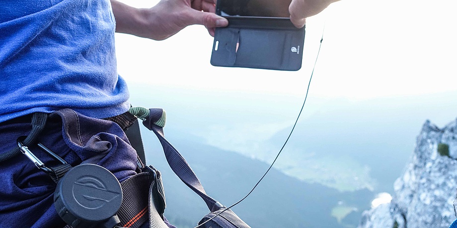 Mobiltelefon mit Seilzug an der Taille befestigt