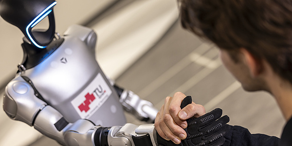 A robot shakes a person's hand