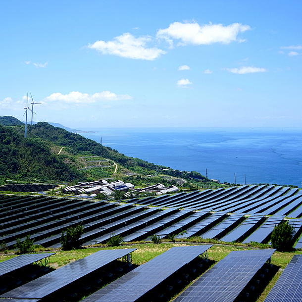 Solar collectors and wind turbines up on a mountain