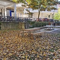 Outdoor Lernort zwischen Mandellstraße 13 und Lessingstraße 25 mit einem Tisch, Bänken und einem Tischtennistisch. 