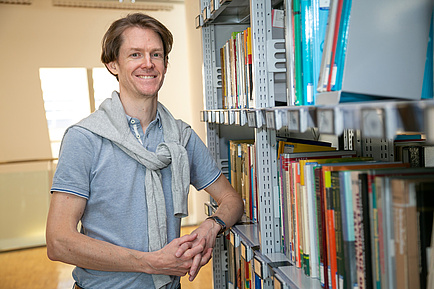 TU Graz-Forscher vor einem Bücherregal