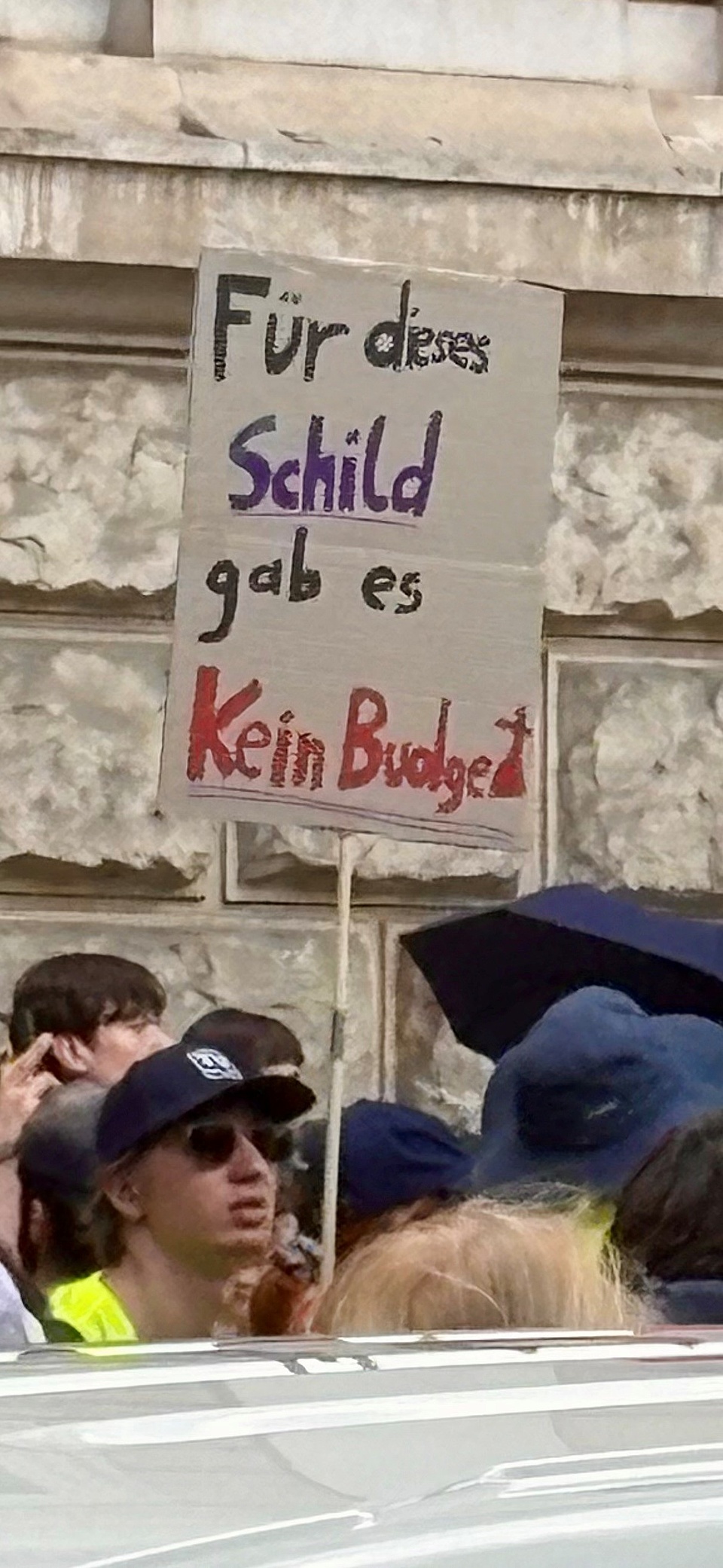 ein Mann hält ein Schild in die Luft