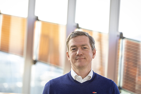 Researcher stands in front of glass parapet