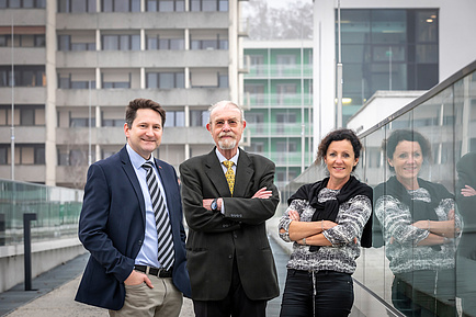 Two gentlemen and a woman on a footbridge