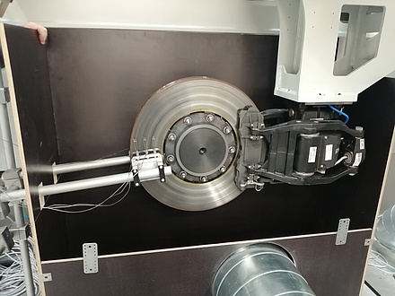 The brake disc of a train is mounted in a test stand. Sensors are located on the left and right of the brake disc.