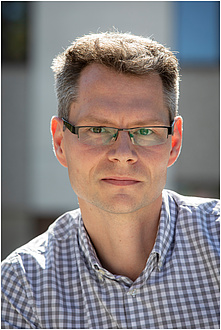 Portrait von Markus Koch in einem blaukarierten Hemd