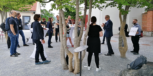 a group of people stands in the courtyard of the Schlossberg museum