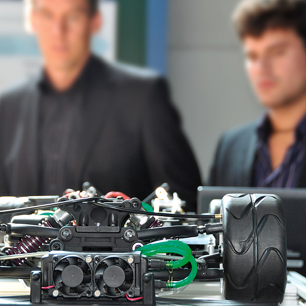 Two men behind a model car. Photo source: Lunghammer - TU Graz