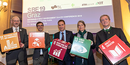 Five people with coloured cardboard cubes in their hands 