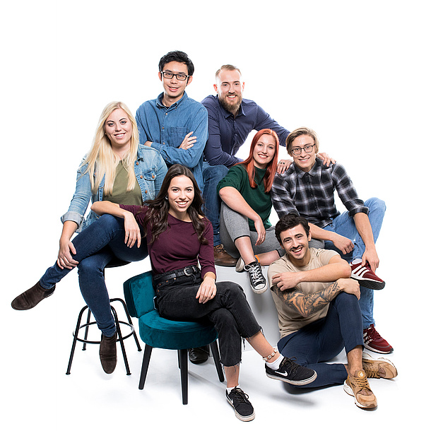 7 young people are sitting on seat blocks. They are holding items in their hands, such as a notebook, a test tube, a concrete model and a circuit board.