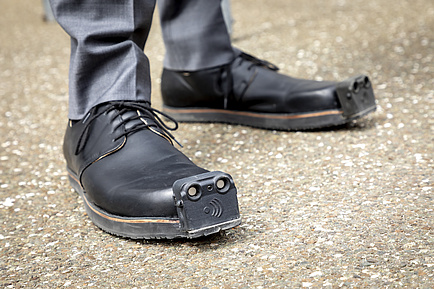 Feet with shoes, an ultrasonic sensor is attached to the toe of the shoe 