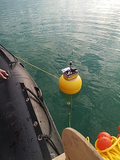 A round object floats in the water, with technical measuring equipment visible on top of it.