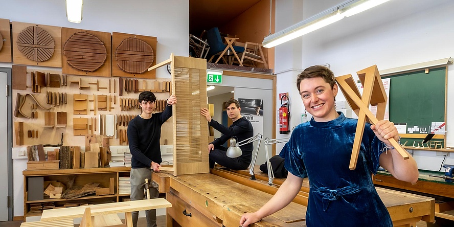 Drei Studierende mit Möbeln in der TU Graz-Holzwerkstatt