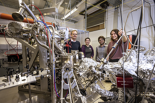 Four people in a physics laboratory