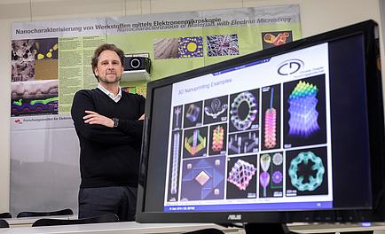 Ein Forscher neben einem Bildschirm mit Abbildung von Nanostrukturen