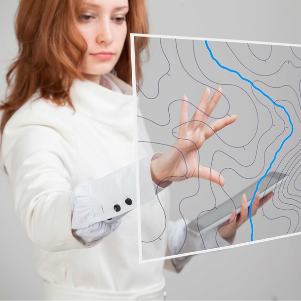 A woman is working on a transparent touch screen.