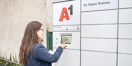 Frau vor Display einer Paketstation