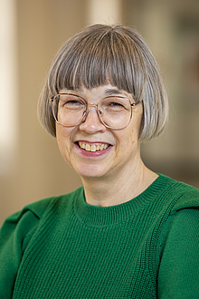 Smiling woman with glasses.