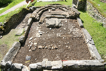 Excavated fragments of a church lie on the ground.