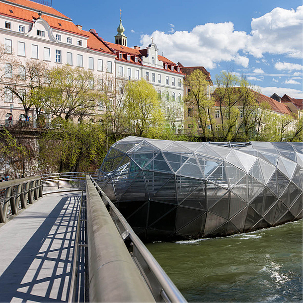 Eine Brücke und die Murinsel von Graz. Bildquelle: Graz Tourismus – Harry Schiffer