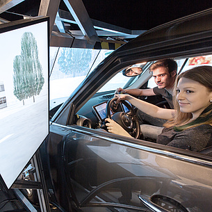 StudentInnen der TU Graz des Bachelorstudiums Maschinenbau sitzen in einem Fahrsimulator.