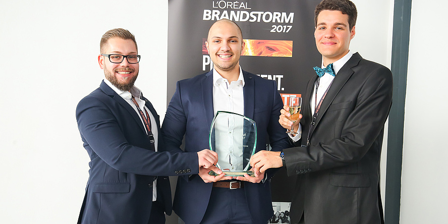 Die drei stolzen Gewinner der L’Oréal Brandstorm Tech-Challenge-Vorausscheidung halten gemeinsam den gläsernen Preis (von links nach rechts): Aleksandar Sargic (mit Bart und Brille), Stefan Stevanovic und Omar Saracevic.