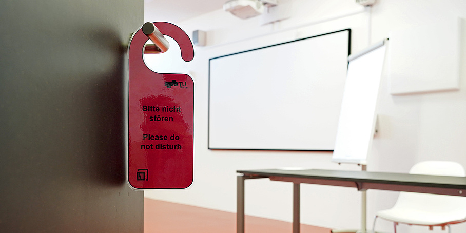 leicht geöffnete Tür mit Türschild "Do not disturb" und Blick in einen hellen Raum