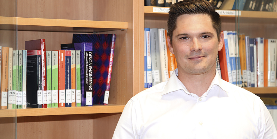 A man in front of a bookshelf.