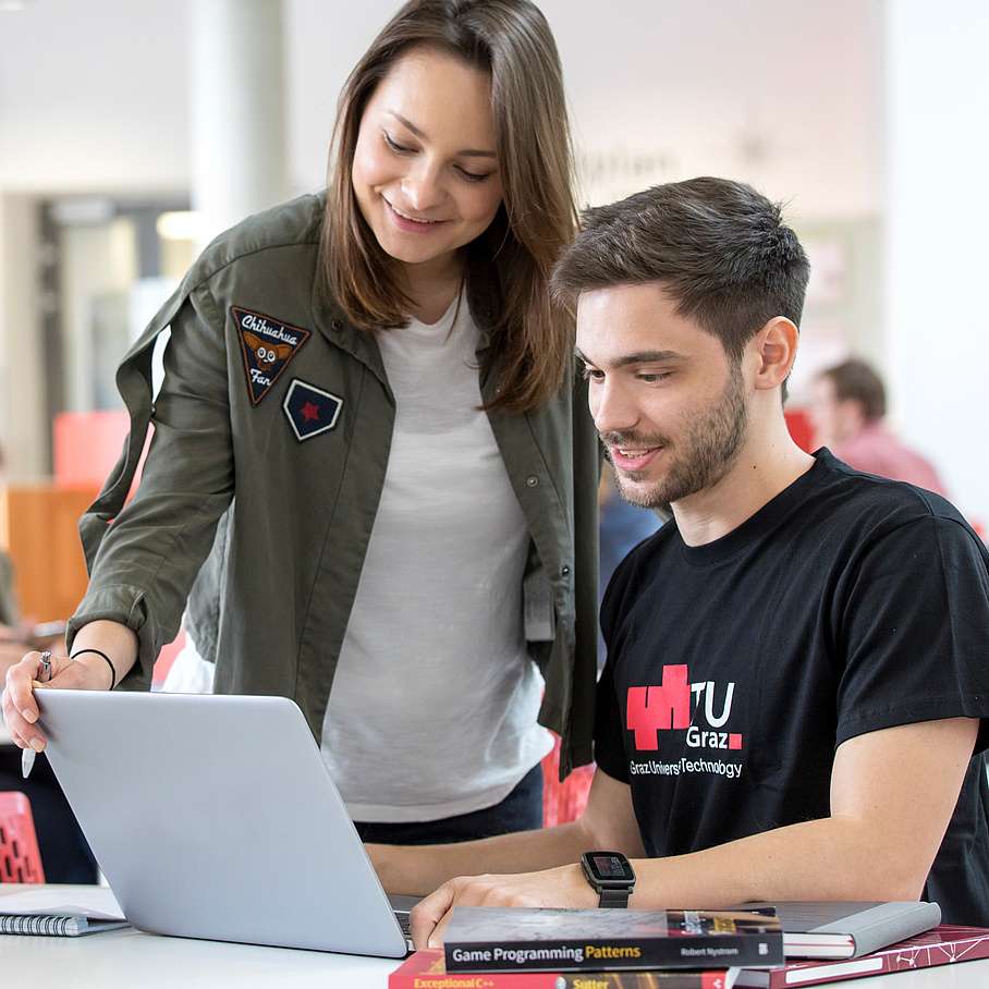 Zwei Studierende vor einem Notebook