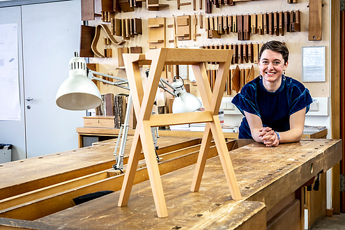 Architekturstudentin mit Hocker in Holzwerkstatt
