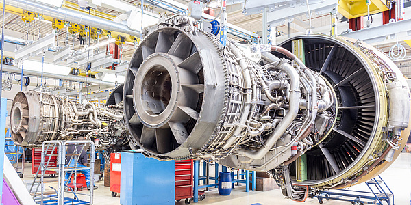 An aircraft engine without its cover in a maintenance hangar.