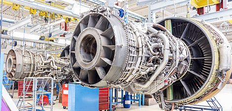 An aircraft engine without its cover in a maintenance hangar.