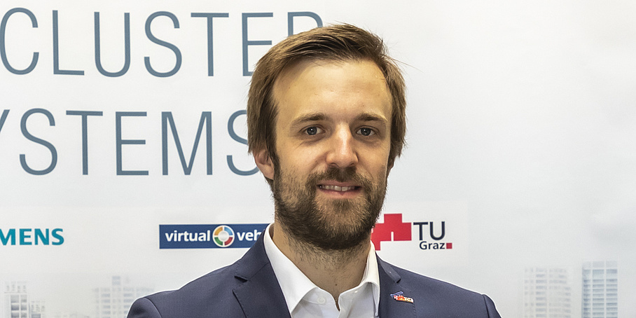 A man with a full beard looks into the camera.