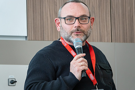 A man speaks into a microphone.