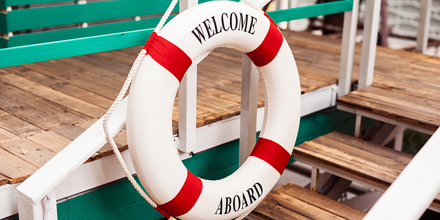 Lifebuoy decoration on a wooden aboard, "Welcome Aboard" written on the Lifebuoy